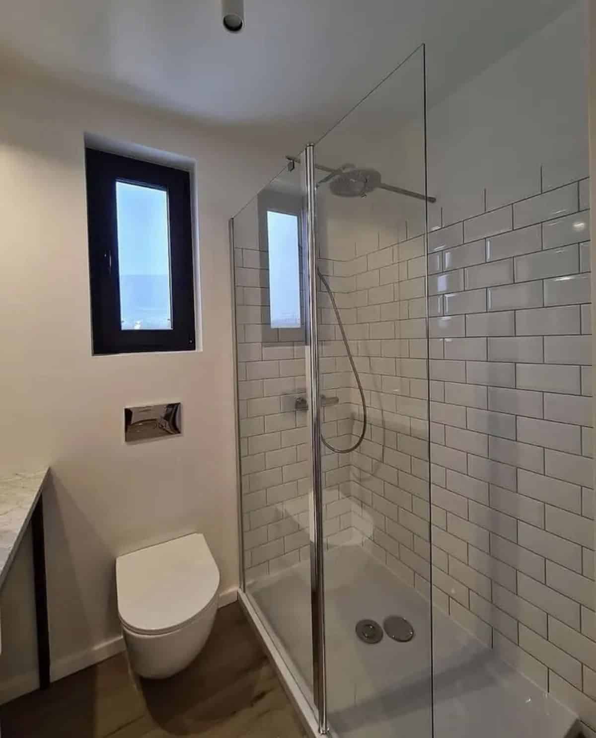 bathroom has a standard fittings with full length shower area and glass enclosure