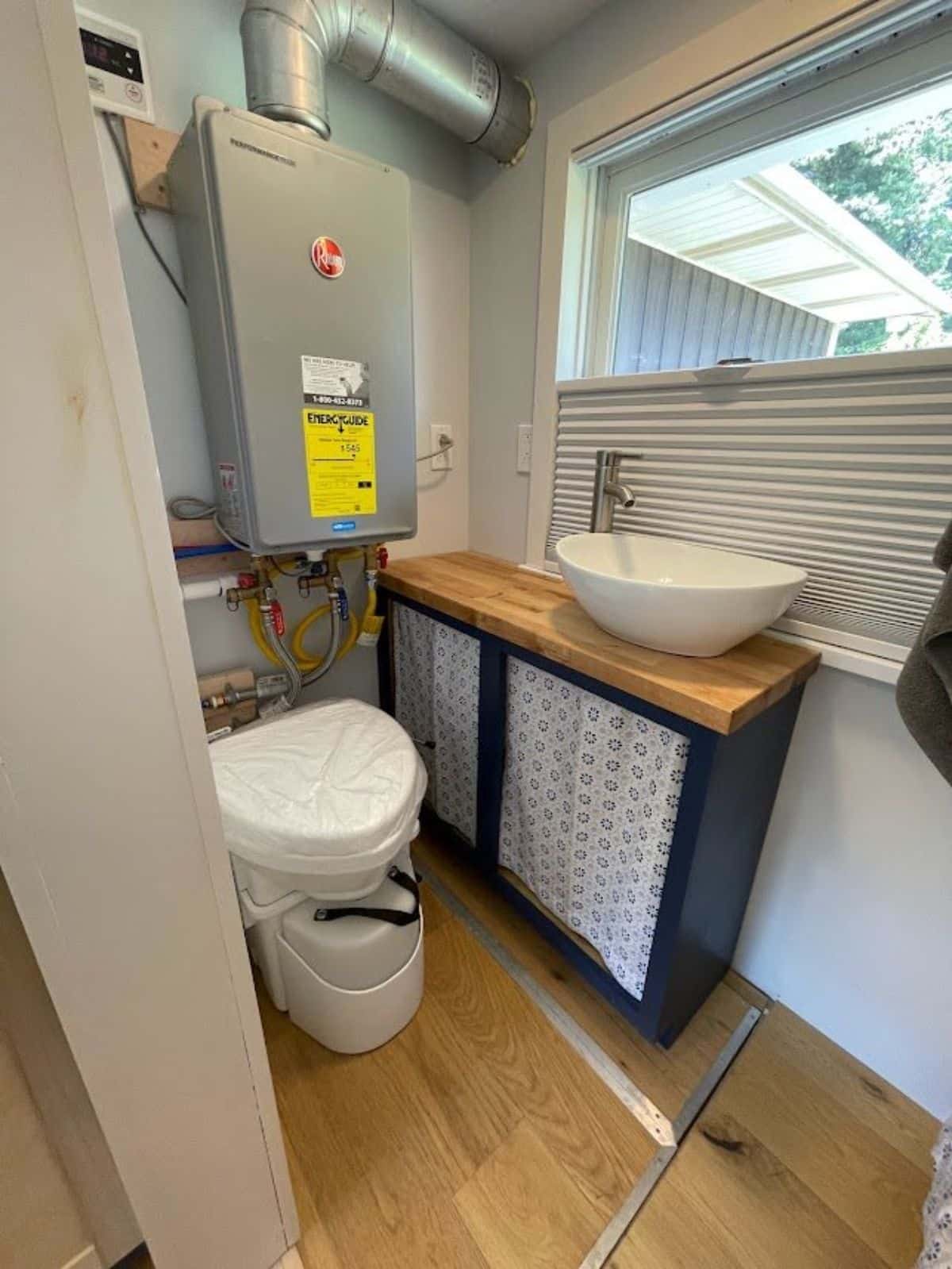 sink with vanity besides the window and a composting toilet