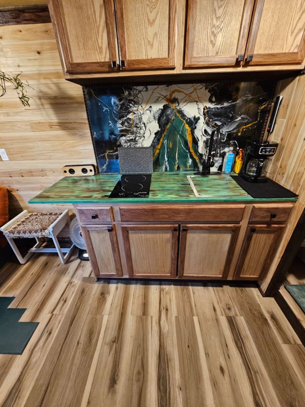 kitchen of reliable tiny house has a countertop with all the essential appliances and storage cabinets