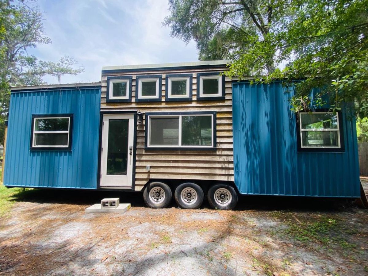 main entrance and stunning blue exterior of spacious tiny home