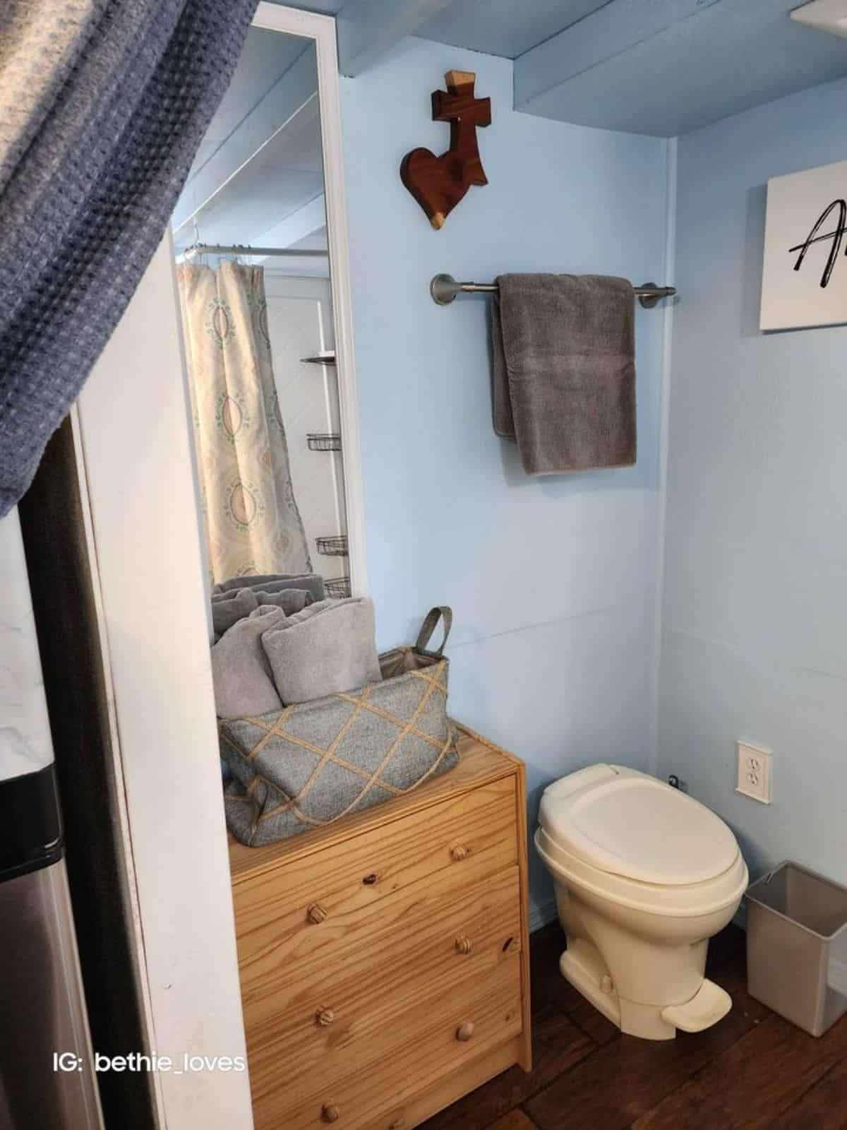 standard toilet and storage cabinets in bathroom of tiny camper home