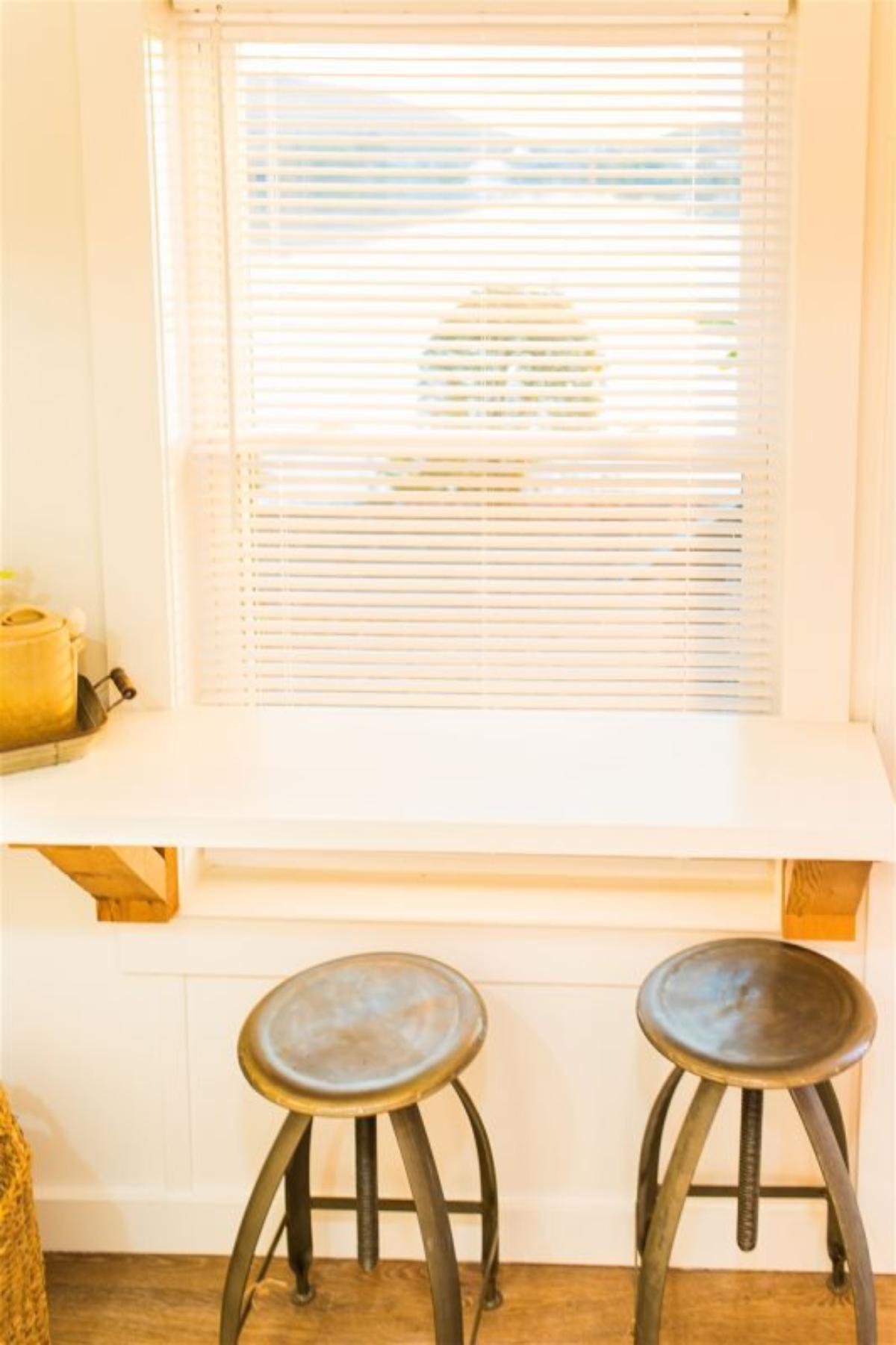 dedicated dining table with stools opposite to the kitchen area