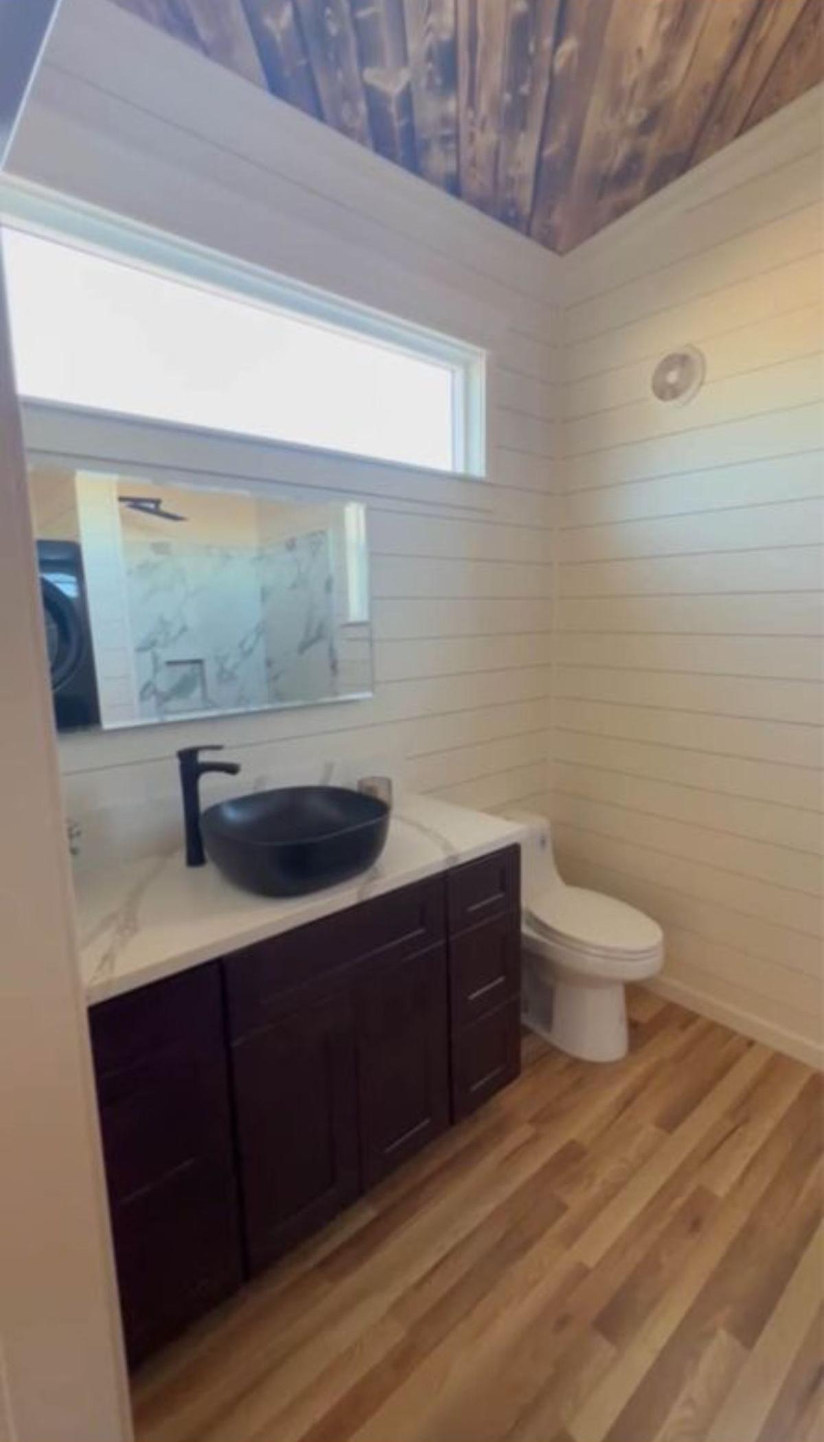bathroom of airy tiny home  has all the standard fittings
