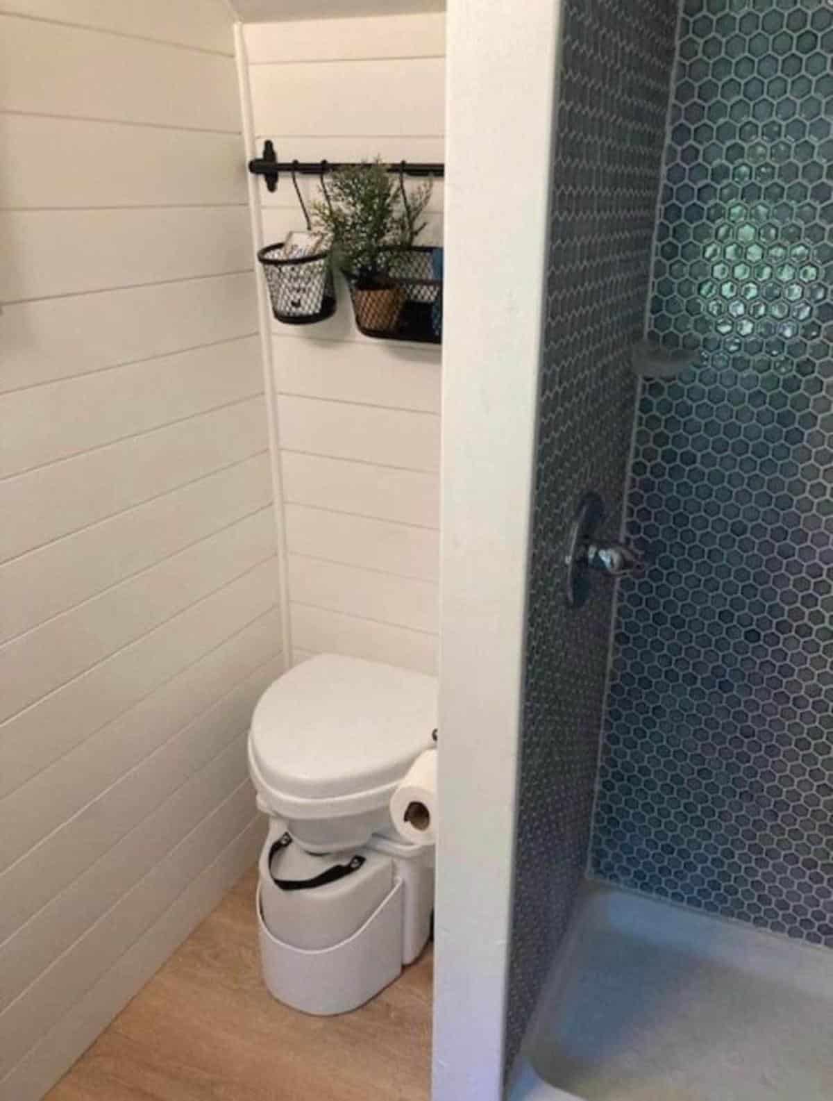 composting toilet and full length shower area in bathroom of offgrid skoolie home